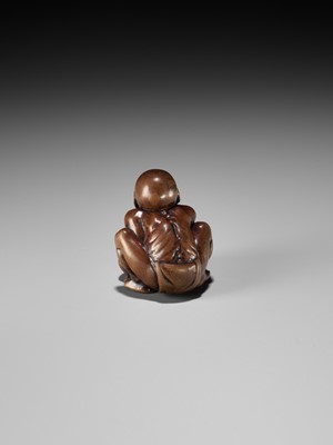 Lot 232 - GYOKUSAI: A FINE WOOD NETSUKE OF A BLIND MASSEUR LIFTING A CHIKARAISHI