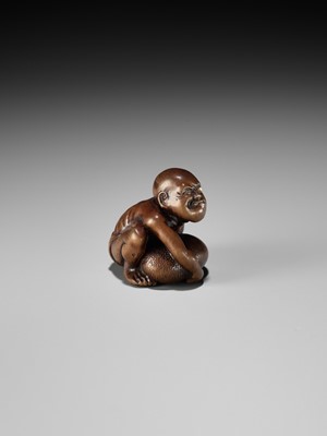 Lot 232 - GYOKUSAI: A FINE WOOD NETSUKE OF A BLIND MASSEUR LIFTING A CHIKARAISHI