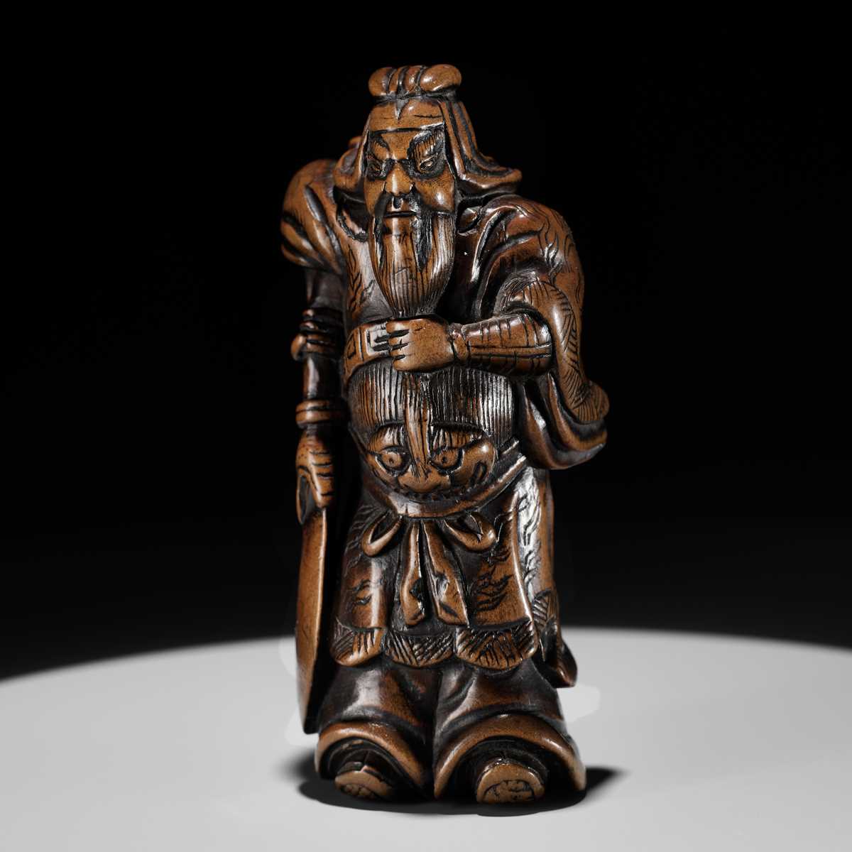 Lot 20 - A POWERFUL WOOD NETSUKE OF KAN’U WITH HIS HALBERD