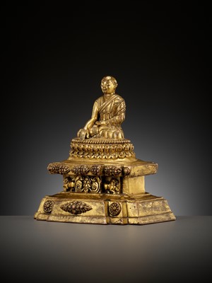 Lot 173 - A GILT-BRONZE FIGURE OF A LAMA ON A STEPPED THRONE, TIBET, 13TH - 14TH CENTURY