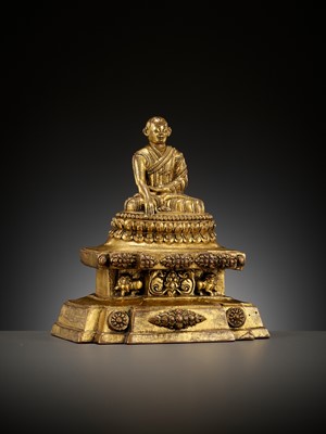 Lot 173 - A GILT-BRONZE FIGURE OF A LAMA ON A STEPPED THRONE, TIBET, 13TH - 14TH CENTURY