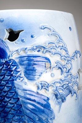 Lot 241 - A LARGE AND HEAVY BLUE AND WHITE ‘KOI’ GARDEN STOOL