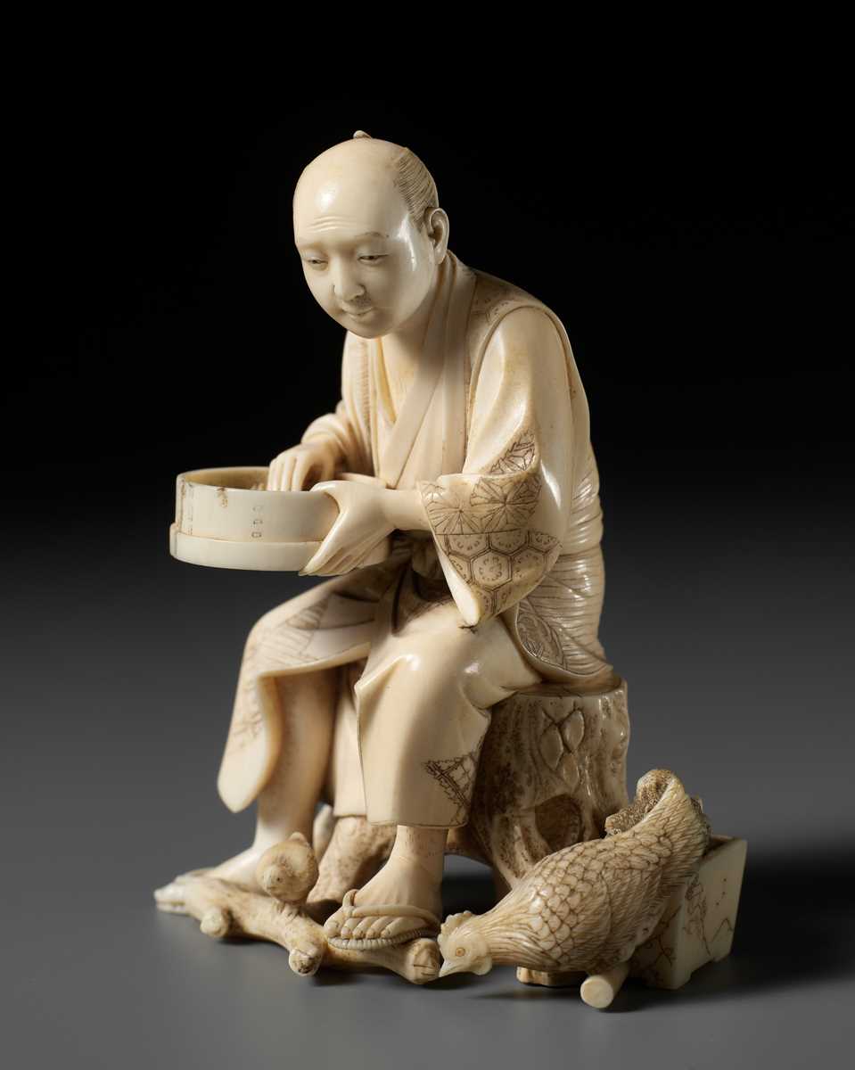 Lot 170 - SEIYO: AN IVORY OKIMONO OF A MAN FEEDING HIS CHICKENS