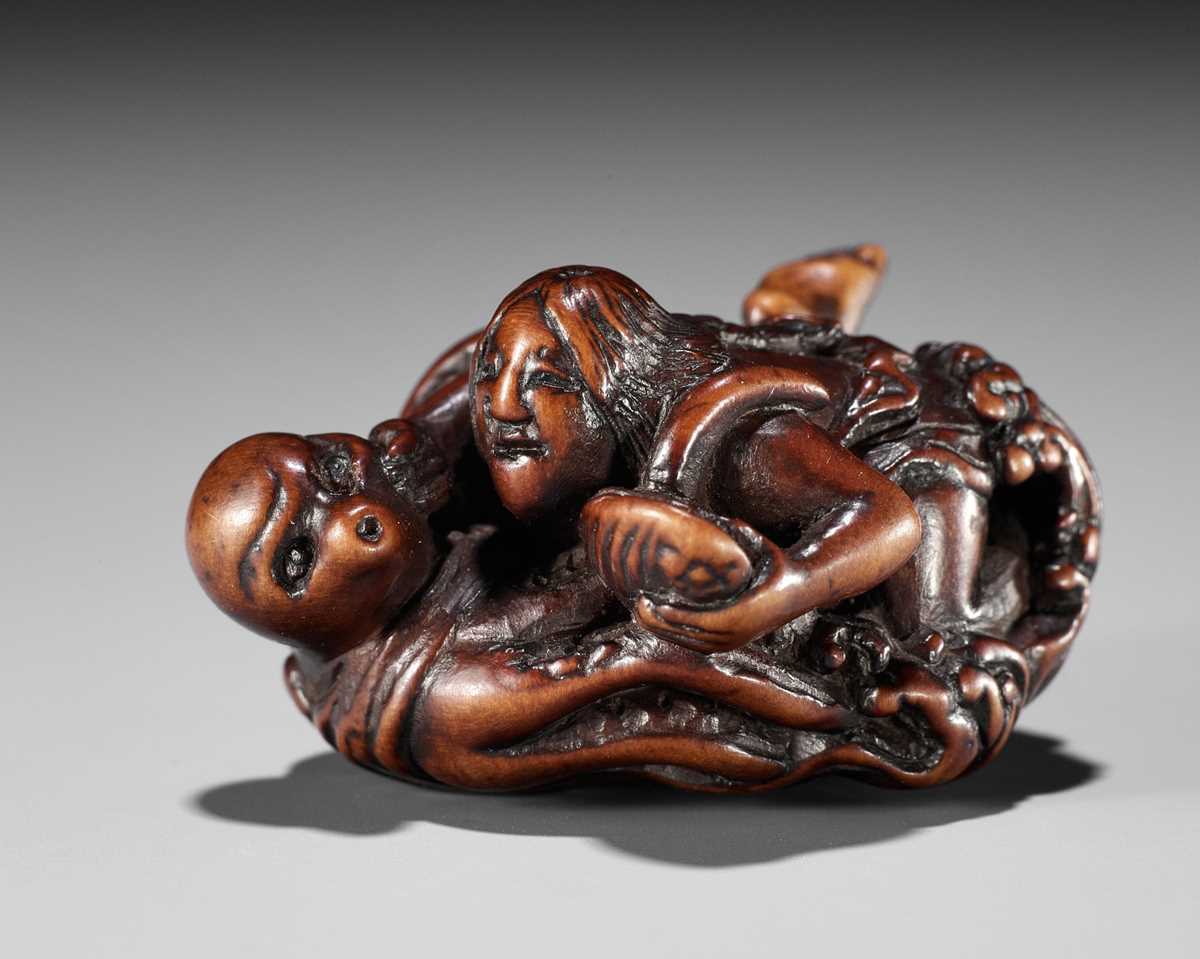 Lot 370 - KOKEI: A FINE WOOD NETSUKE OF AMA STRUGGLING WITH AN OCTOPUS