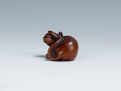 Lot 396 - AN OLD WOOD NETSUKE OF A RECUMBENT CAT