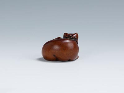 Lot 396 - AN OLD WOOD NETSUKE OF A RECUMBENT CAT