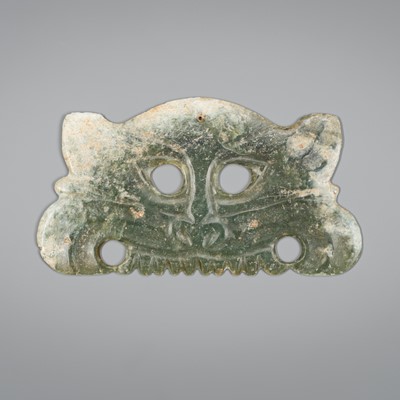 Lot 1767 - AN ARCHAISTIC HONGSHAN STYLE CELADON JADE TOOTHED ANIMAL MASK PENDANT