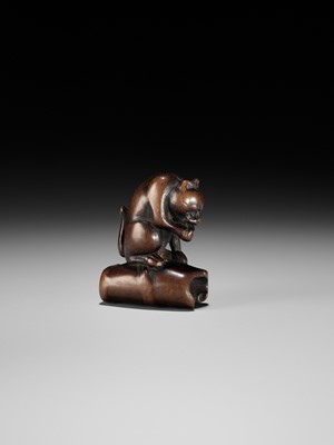 Lot 128 - A WOOD NETSUKE OF A TIGER ON BAMBOO