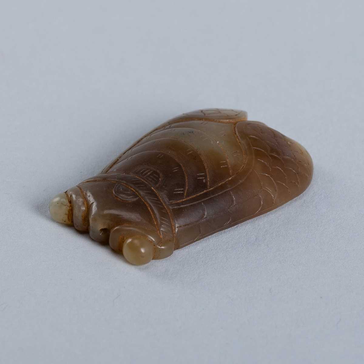 AN ARCHAISTIC CELADON AND BROWN JADE CARVING OF A CICADA, c. 1900s