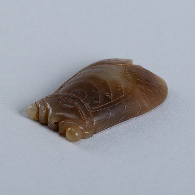 AN ARCHAISTIC CELADON AND BROWN JADE CARVING OF A CICADA, c. 1900s