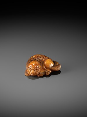 Lot 283 - A VERY RARE CLOUDY AMBER NETSUKE OF A RECUMBENT SHISHI