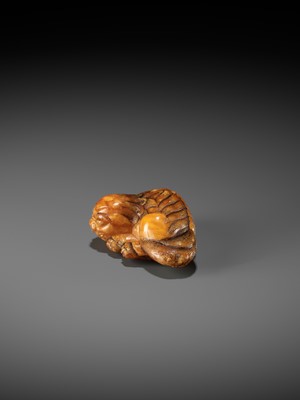 Lot 283 - A VERY RARE CLOUDY AMBER NETSUKE OF A RECUMBENT SHISHI