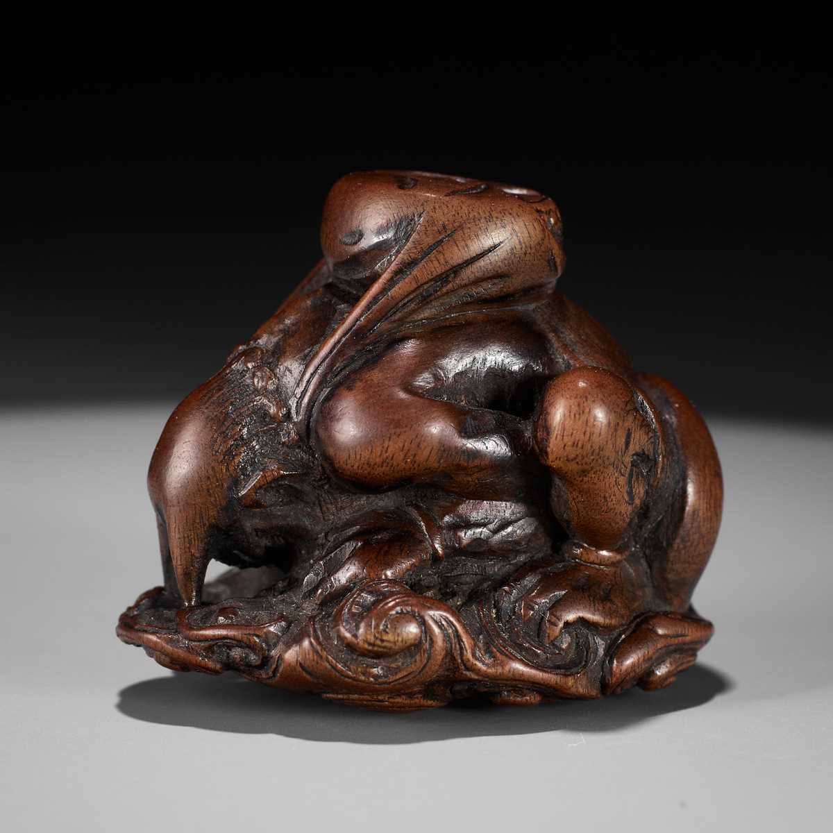 Lot 401 - ITTAN: A FINE WOOD NETSUKE OF RAIJIN PEERING THROUGH CLOUDS