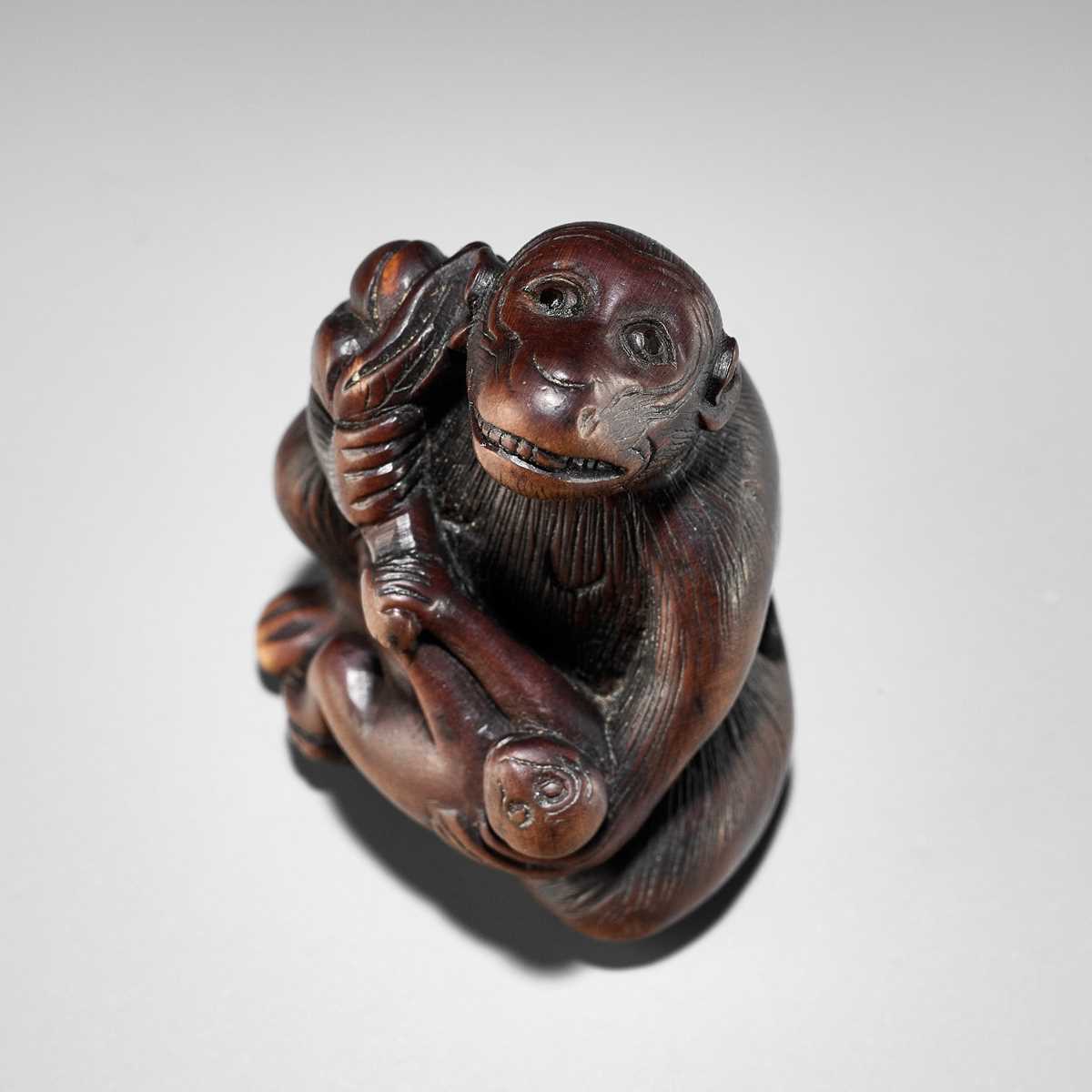 Lot 348 - A HUMOROUS WOOD NETSUKE OF TWO MONKEYS AND PEACH, ATTRIBUTED TO MITSUHARU