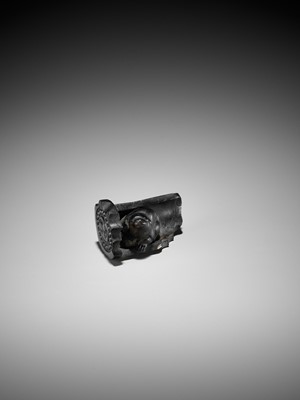 Lot 300 - A RARE HORN NETSUKE OF A PUPPY NESTLED WITHIN A ROOF TILE, ATTRIBUTED TO HORAKU