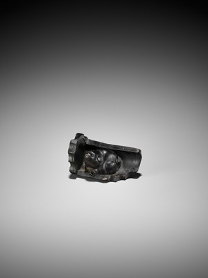 Lot 300 - A RARE HORN NETSUKE OF A PUPPY NESTLED WITHIN A ROOF TILE, ATTRIBUTED TO HORAKU