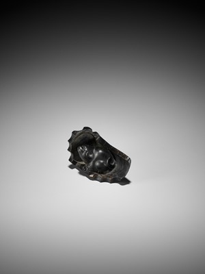 Lot 300 - A RARE HORN NETSUKE OF A PUPPY NESTLED WITHIN A ROOF TILE, ATTRIBUTED TO HORAKU