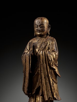 Lot 311 - A GILT-LACQUERED WOOD FIGURE OF ANANDA, YUAN TO MING DYNASTY