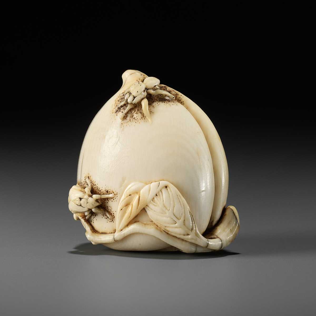 Lot 40 - AN IVORY NETSUKE OF A PEACH WITH INSECTS