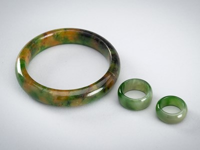 A GROUP OF TWO GREEN JADEITE RINGS AND A BANGLE