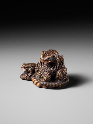 Lot 386 - MASANAO: A FINE WOOD NETSUKE OKIMONO OF A TOAD WITH TWO YOUNG ON WARAJI