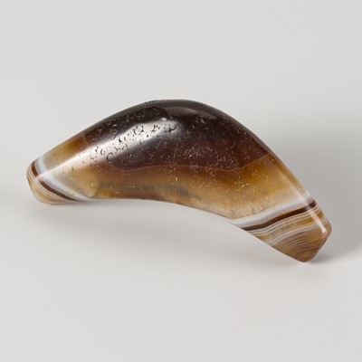 Lot 1090 - A BOW-SHAPED HIMALAYAN BANDED AGATE BEAD, 19TH CENTURY OR EARLIER