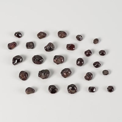 Lot 1661 - A LOT WITH 26 PERSIAN RAW GARNET BEADS, c. 10TH – 12TH CENTURY OR EARLIER
