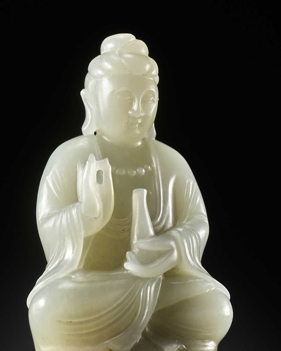 Lot 114 - A SMALL PALE CELADON JADE FIGURE OF GUANYIN, QING DYNASTY