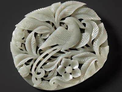 Lot 105 - A RETICULATED PALE CELADON ‘PHOENIX AND PRUNUS’ PLAQUE, YUAN TO EARLY MING DYNASTY