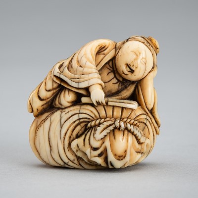 Lot 1314 - A FINE IVORY NETSUKE DEPICTING A BOY ON HOTEI’S SACK, EDO PERIOD