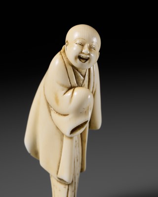 Lot 104 - AN EARLY OSAKA SCHOOL IVORY NETSUKE OF AN AMUSED YAKKO (SAMURAI'S SERVANT)