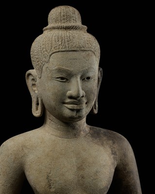 Lot 593 - A LARGE SANDSTONE FIGURE OF A MALE DEITY, ANGKOR PERIOD, BAPHUON STYLE