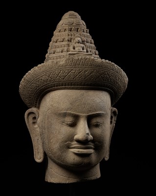 Lot 182 - A MONUMENTAL SANDSTONE HEAD OF AVALOKITESHVARA, ANGKOR PERIOD