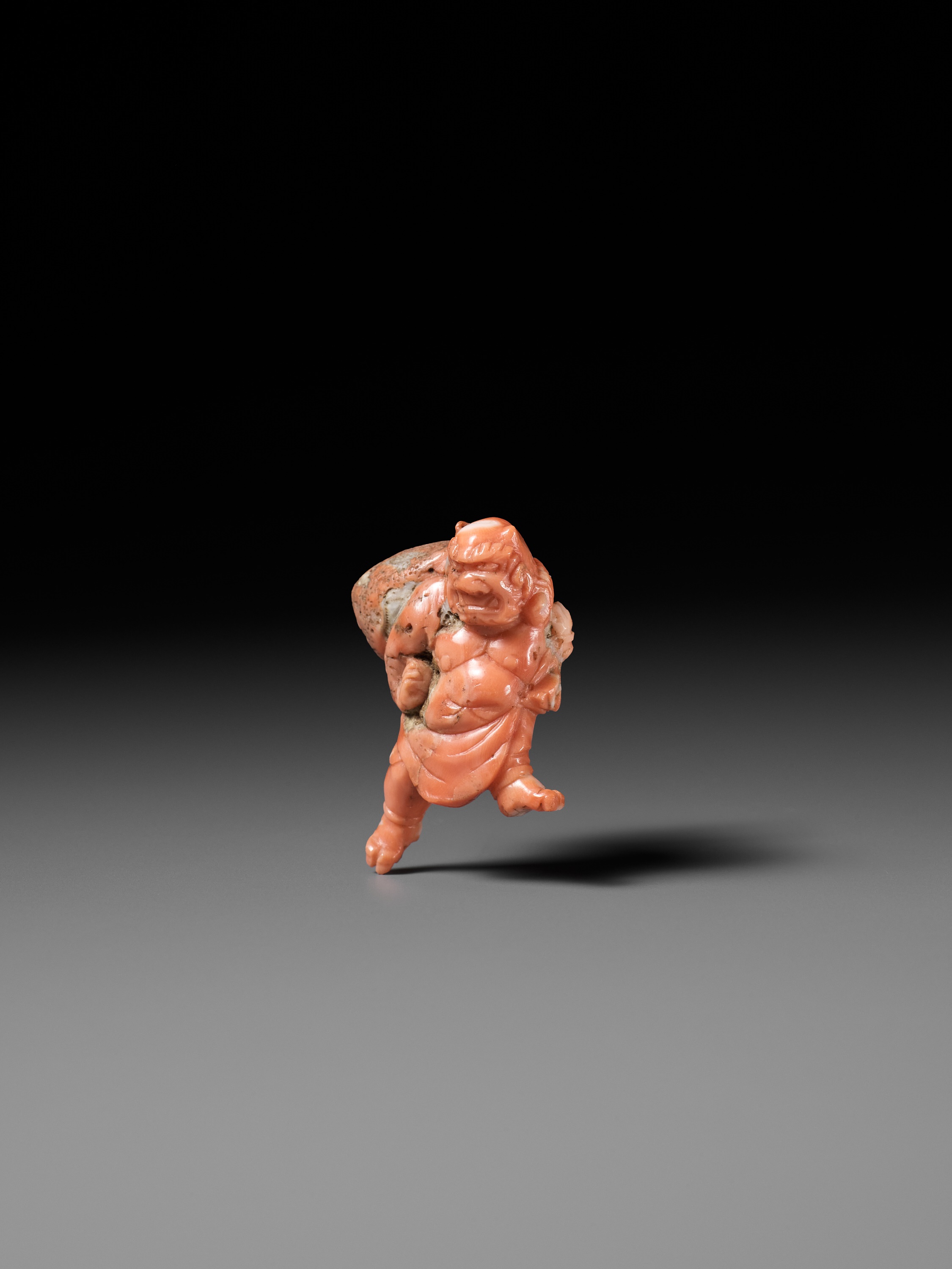 Lot 304 - A VERY RARE SOLID CORAL NETSUKE OF FUJIN