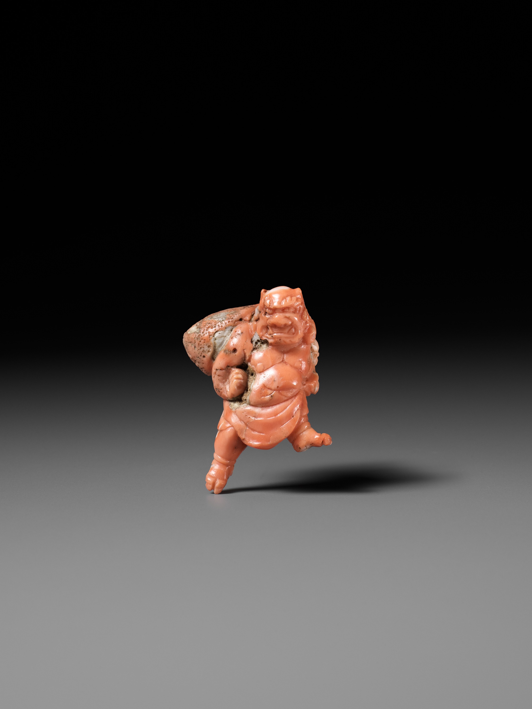 Lot 304 - A VERY RARE SOLID CORAL NETSUKE OF FUJIN