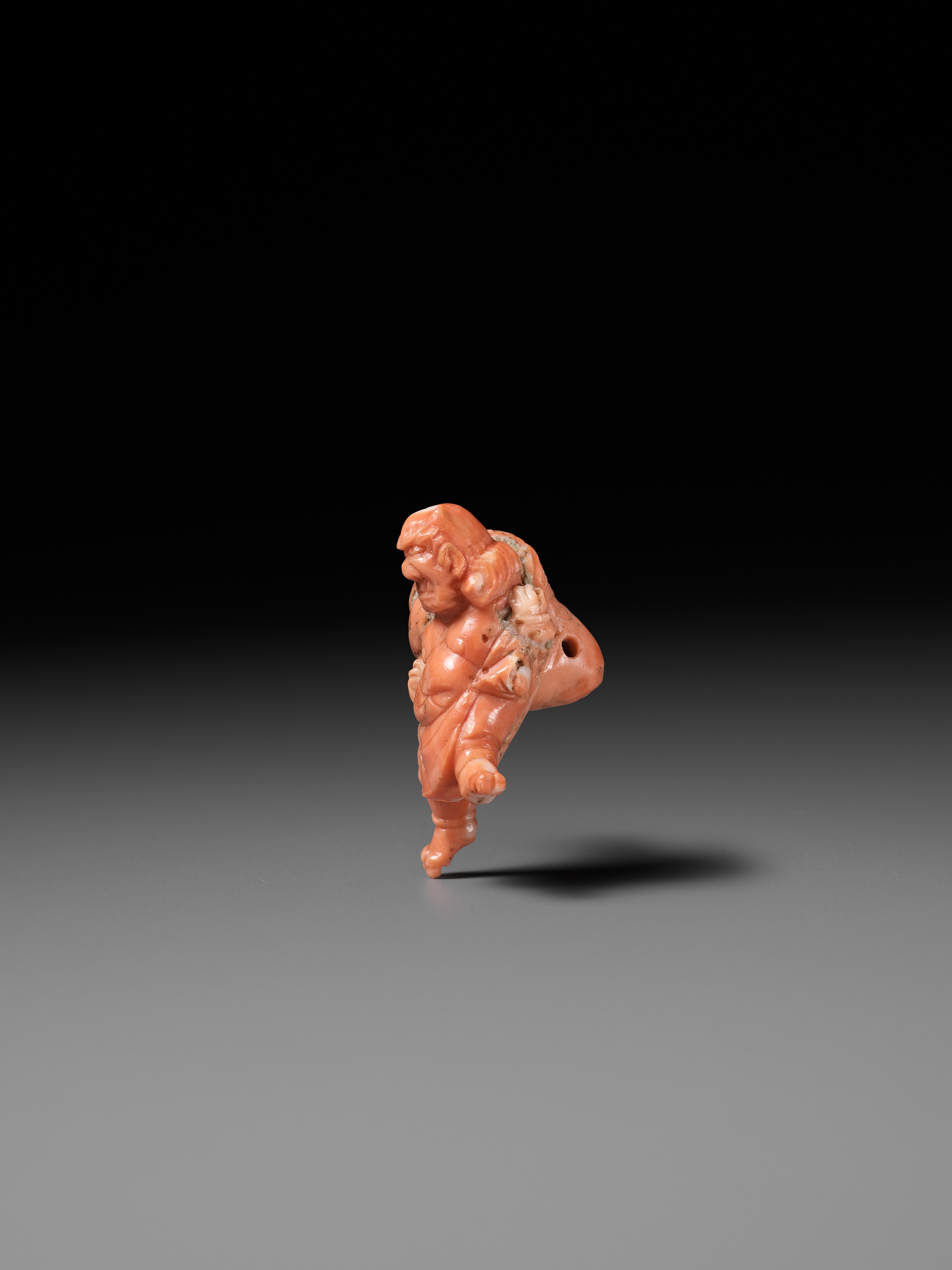 Lot 304 - A VERY RARE SOLID CORAL NETSUKE OF FUJIN