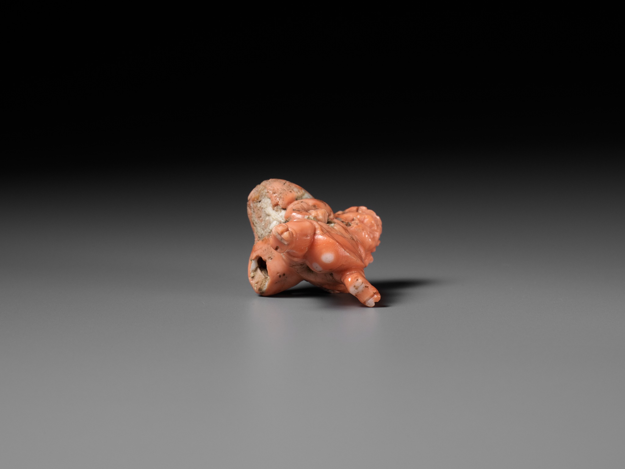 Lot 304 - A VERY RARE SOLID CORAL NETSUKE OF FUJIN