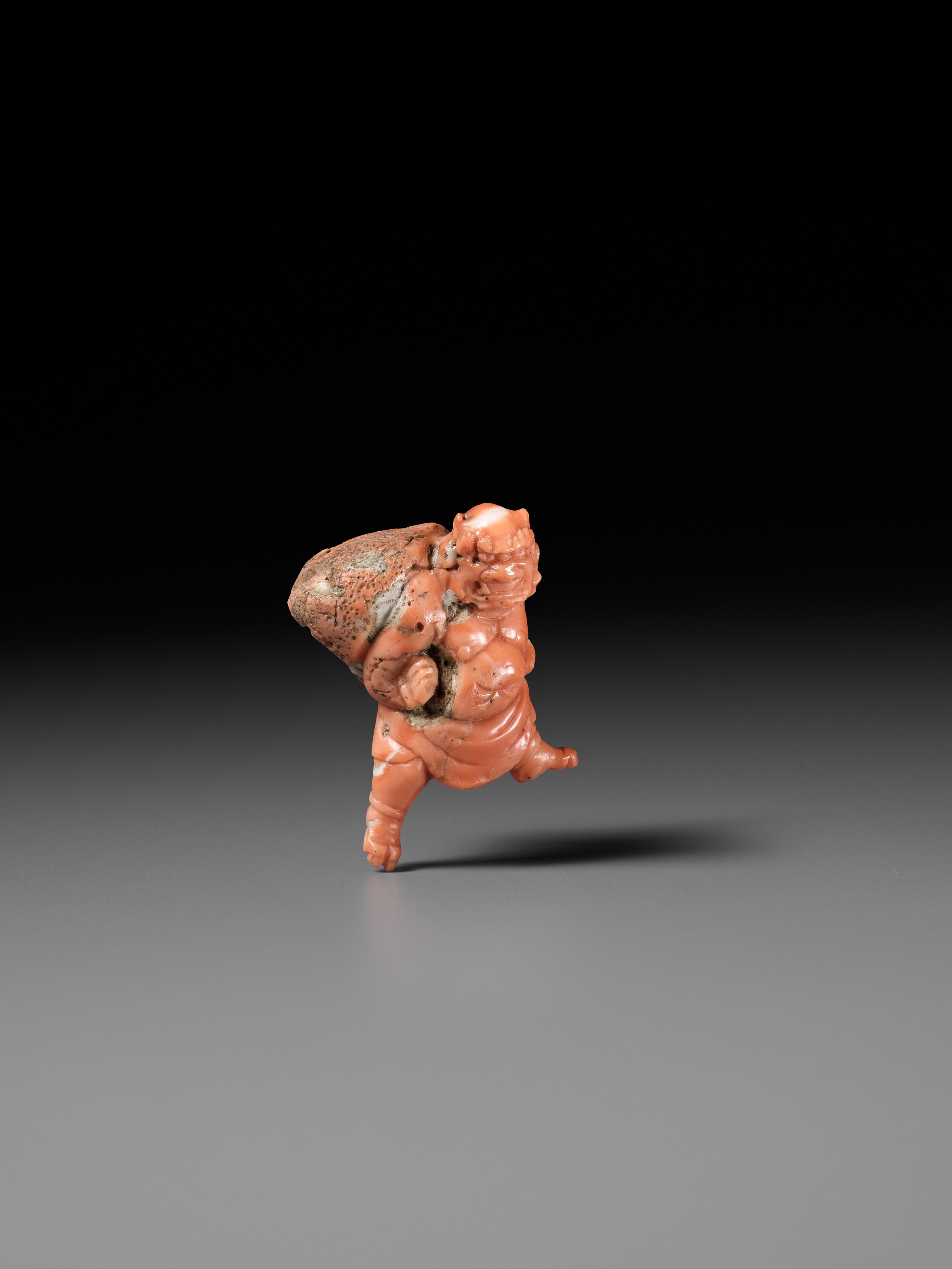 Lot 304 - A VERY RARE SOLID CORAL NETSUKE OF FUJIN