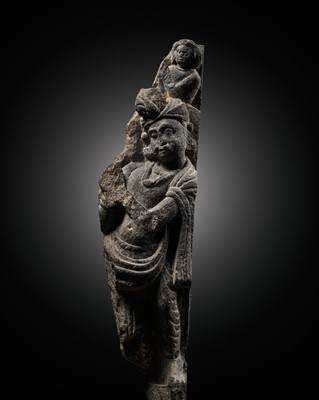 Lot 619 - A GRAY SCHIST FIGURE OF MAITREYA WITH WORSHIPPER, ANCIENT REGION OF GANDHARA