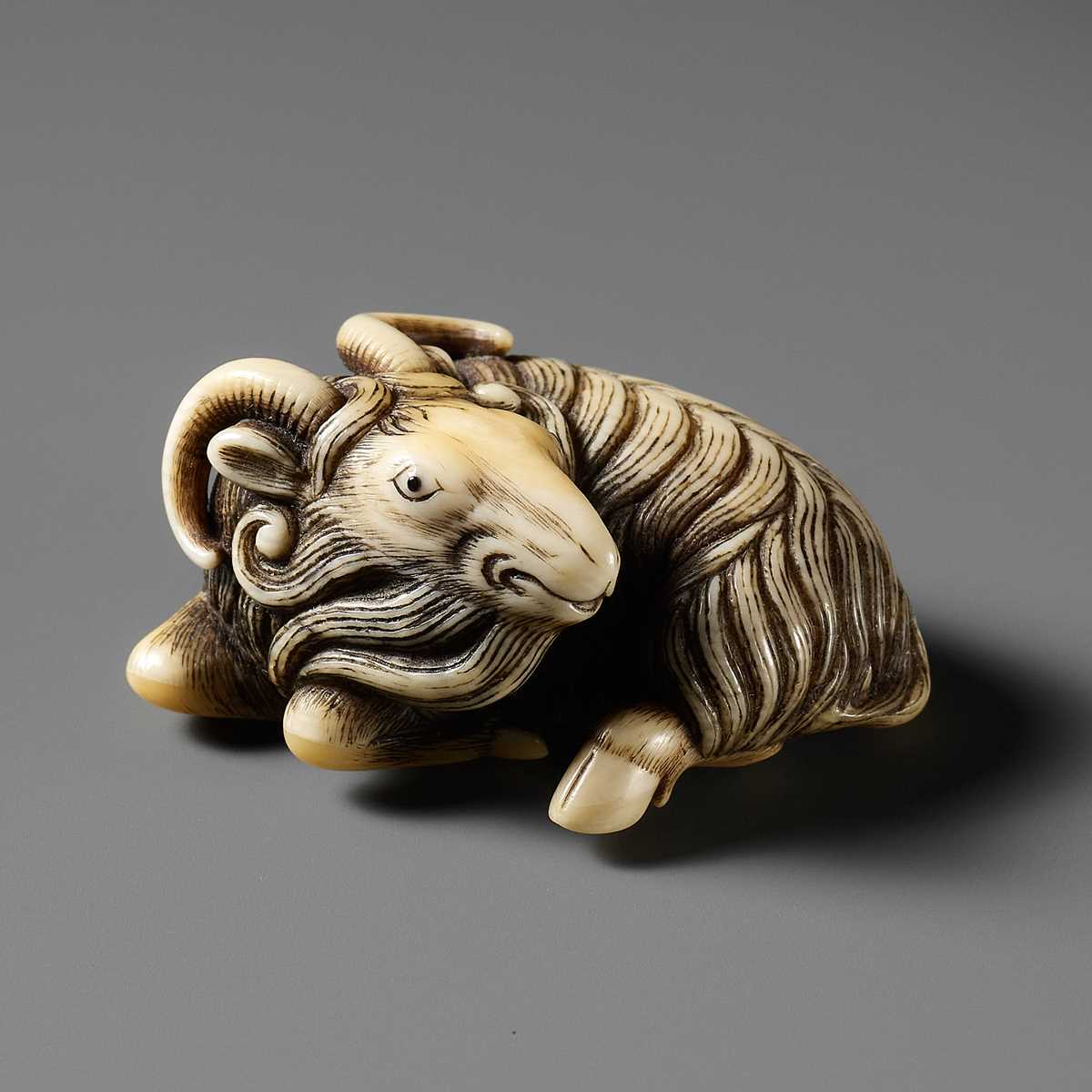 Lot 44 - A FINE MARINE IVORY NETSUKE OF A RECLINING GOAT