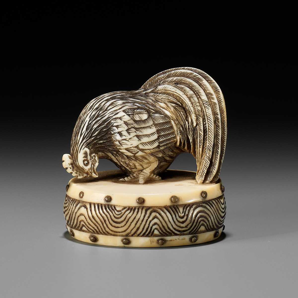 Lot 53 - A FINE KYOTO SCHOOL IVORY NETSUKE OF A COCKEREL ON A WAR DRUM