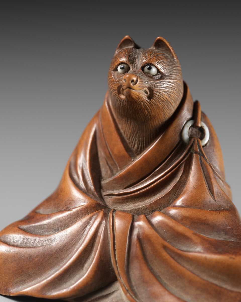 Lot 59 - ANRAKU: A FINE AND HUMOROUS WOOD NETSUKE OF TANUKI DISGUISED AS A PRIEST