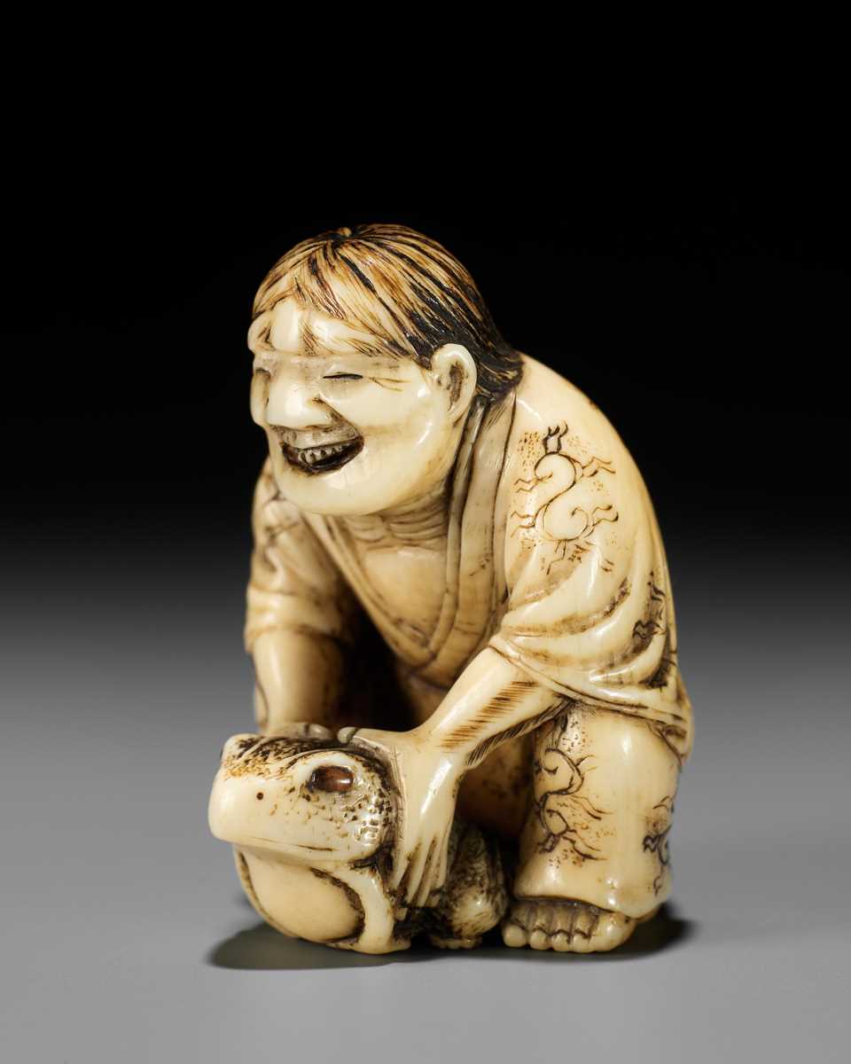 Lot 71 - MASATSUGU: AN AMUSING OSAKA SCHOOL IVORY NETSUKE OF GAMA SENNIN LIFTING HIS TOAD