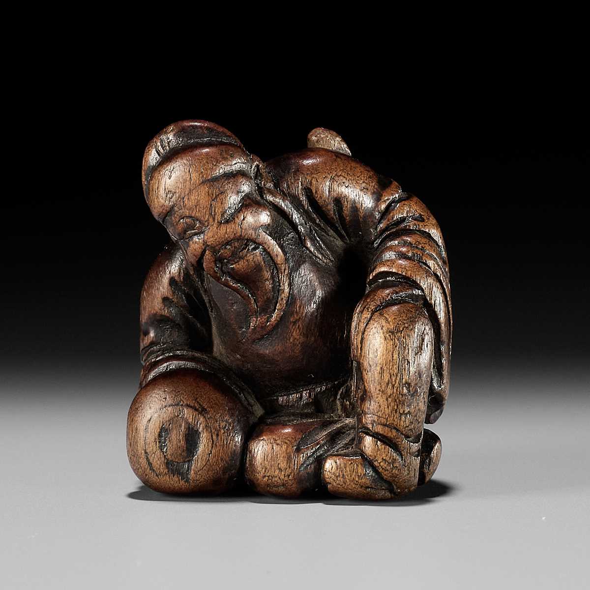 AN OLD WOOD NETSUKE OF A CHINESE SCHOLAR