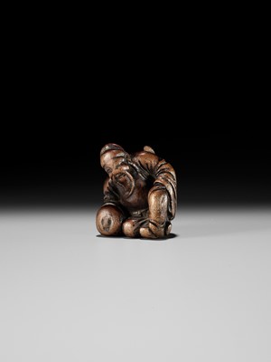 AN OLD WOOD NETSUKE OF A CHINESE SCHOLAR