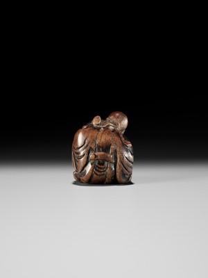 AN OLD WOOD NETSUKE OF A CHINESE SCHOLAR