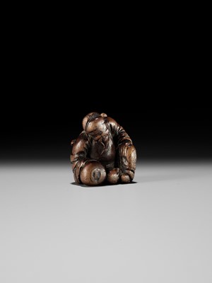 AN OLD WOOD NETSUKE OF A CHINESE SCHOLAR