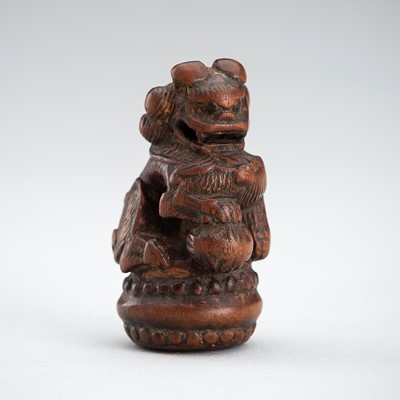 A WOOD NETSUKE OF A SHISHI WITH BALL, 19TH CENTURY