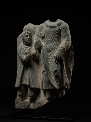 Lot 336 - A LARGE GRAY SCHIST RELIEF DEPICTING BUDDHA AND A ROYAL DONOR, ANCIENT REGION OF GANDHARA