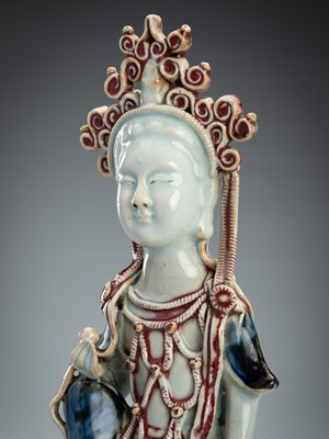 Lot 1924 - A COPPER RED AND UNDERGLAZE BLUE PAINTED FIGURE OF GUANYIN, LATE QING DYNASTY TO REPUBLIC PERIOD